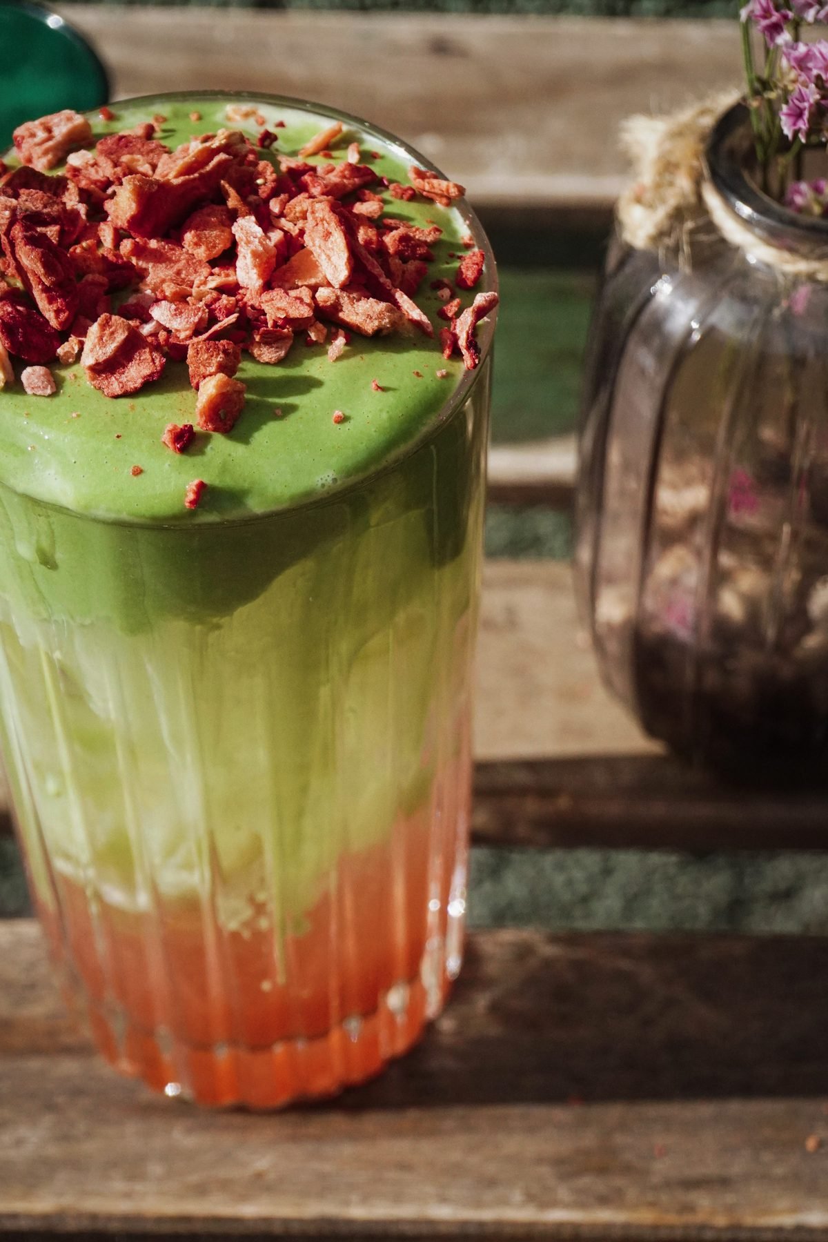 Matcha latte se sušenými jahodami na dřevěném stolku