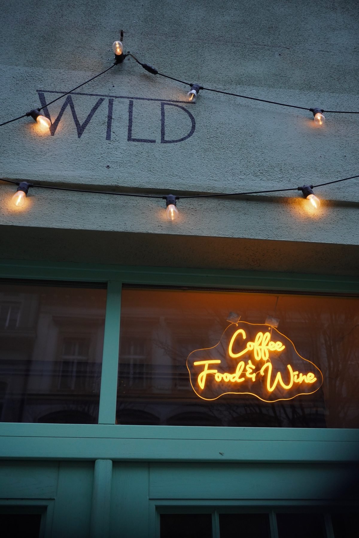 Vchod do Wild Cafe v Záhřebské ulici s nápisem WILD a neonem Coffee Food & Wine