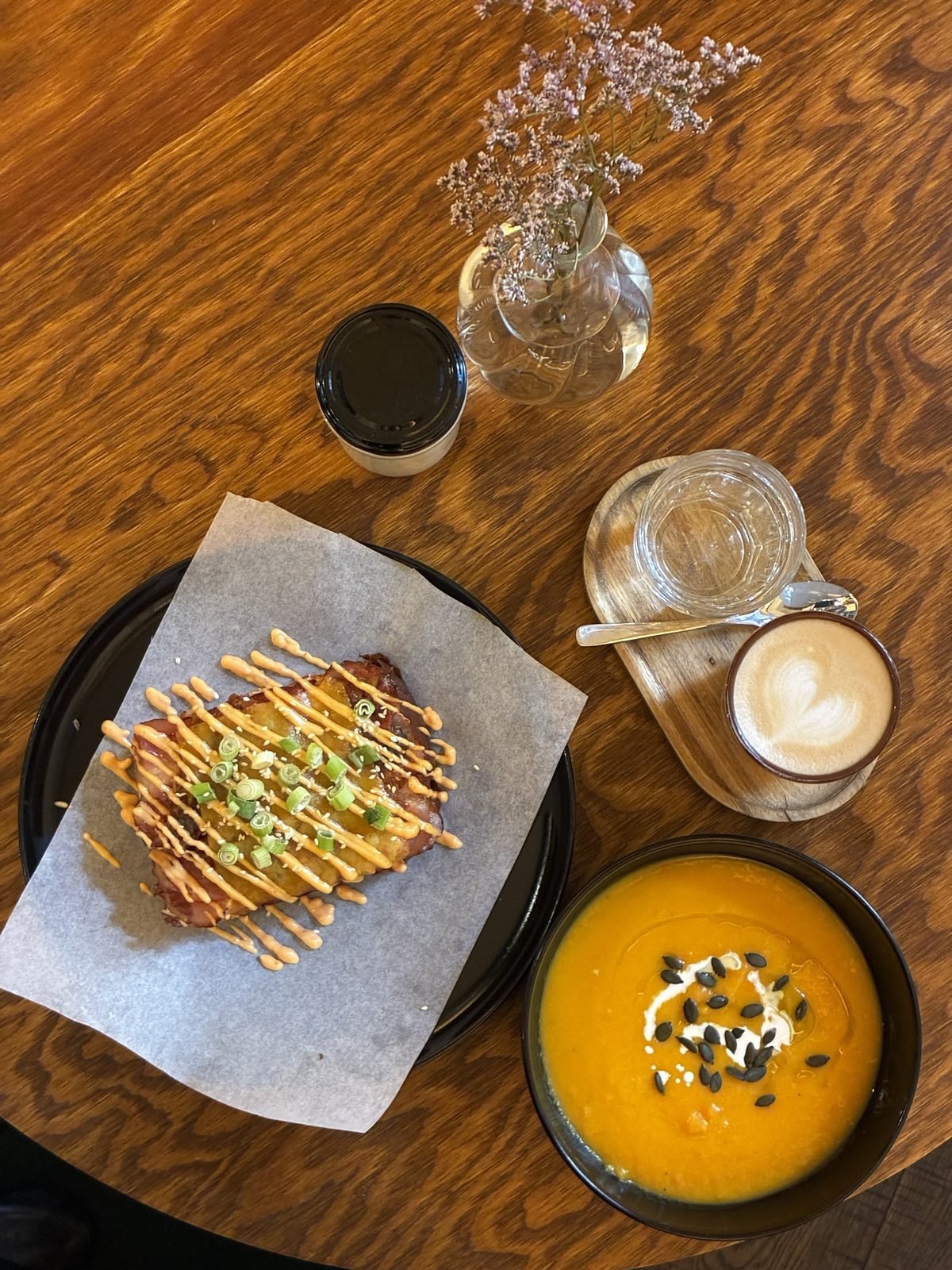 Tom's toust s vejcem 63 °C, dýňová polévka a cappuccino na dubovém stole ve Wild Cafe